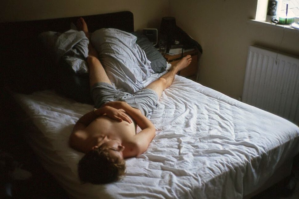 Девушка лежа на кровати снимает на видео камеру домашнюю мастурбацию