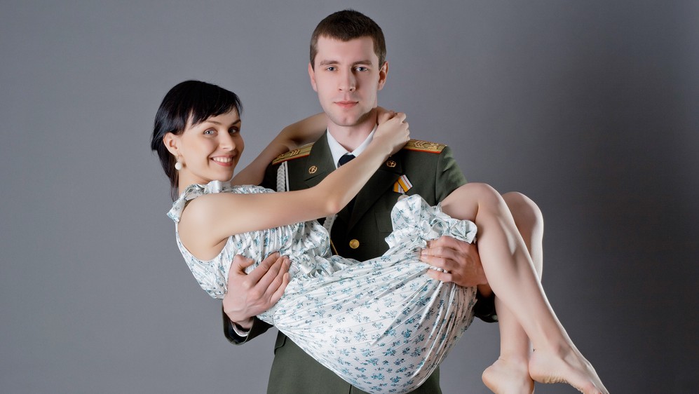 Солдат держит фото девушки в руках сидя