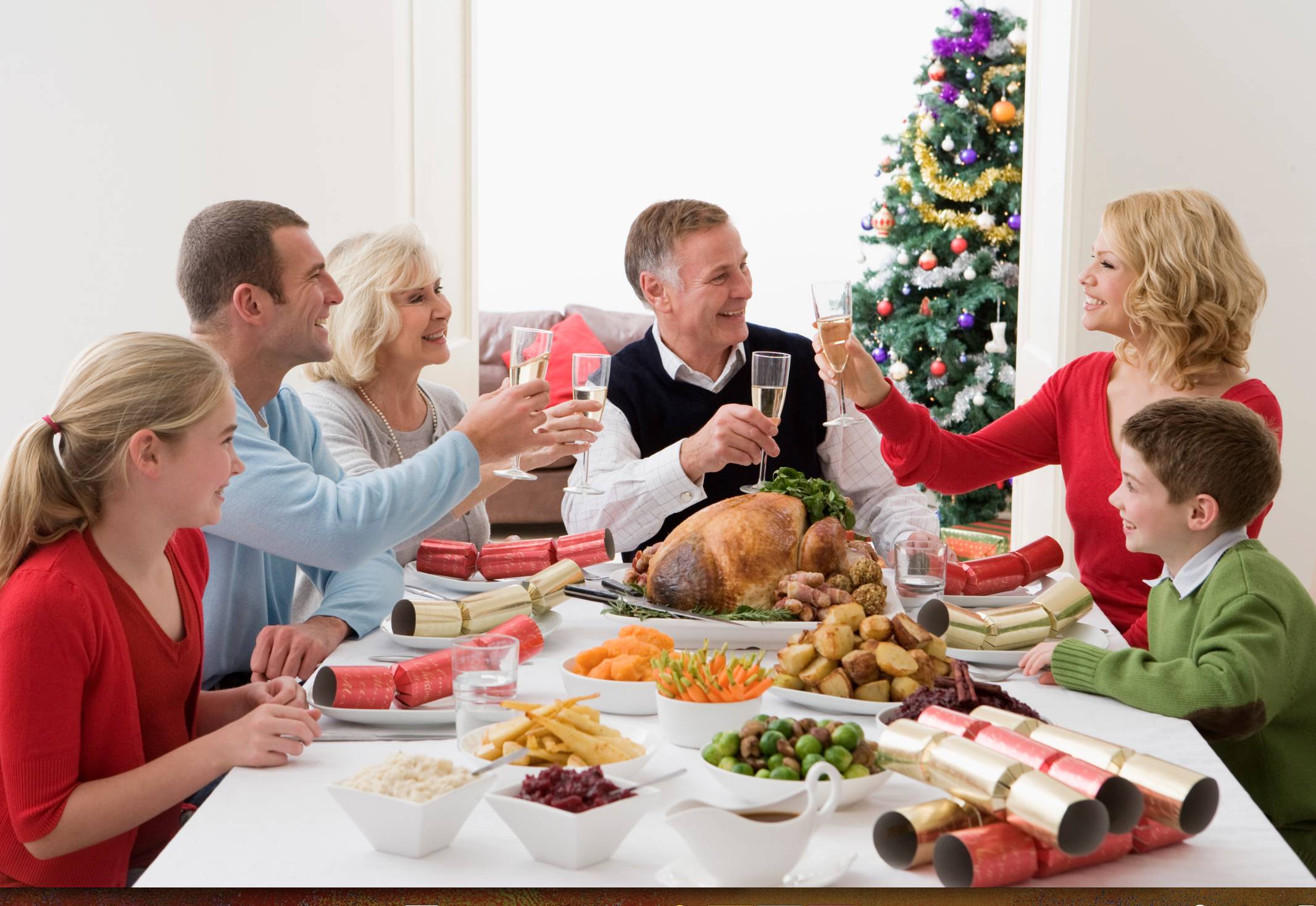 Семья отмечает новый год. Семья за праздничным столом. Люди за праздничным столом. Семейное застолье. Новогодний ужин с семьей.