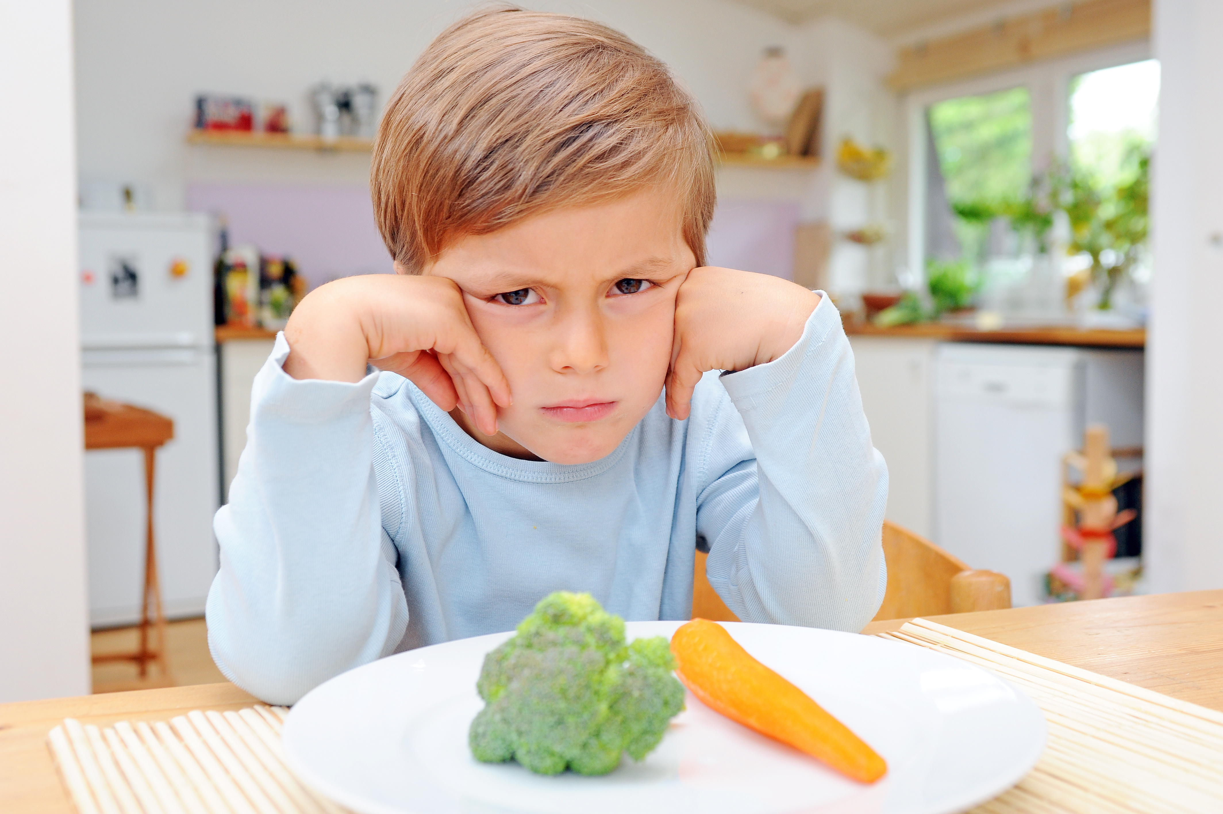 Не вкусно. Ребенок не хочет есть овощи. Дети за столом. Ребенок. Еда для детей.