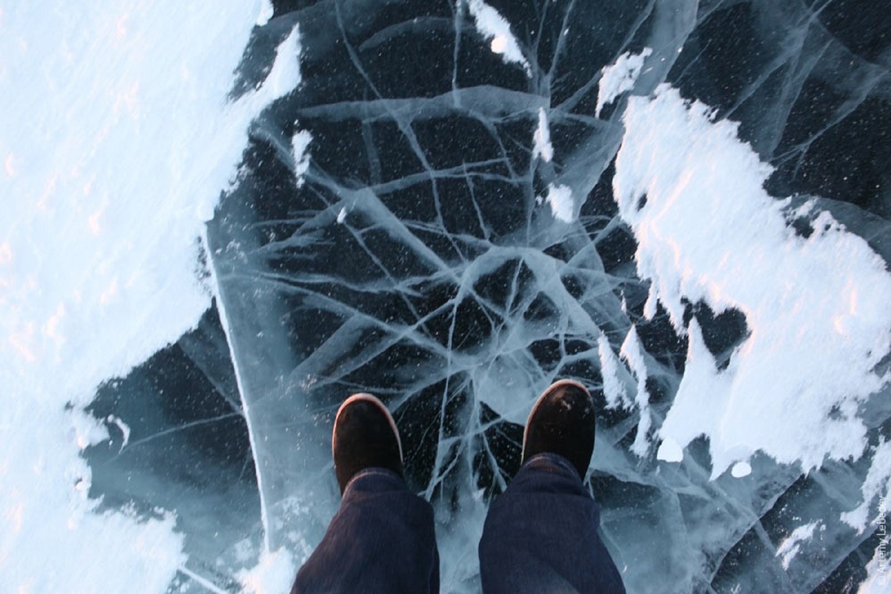 Трещины на снегу. Лед под ногами. Хрупкий лед. Непрочный лед. Ноги на льду.